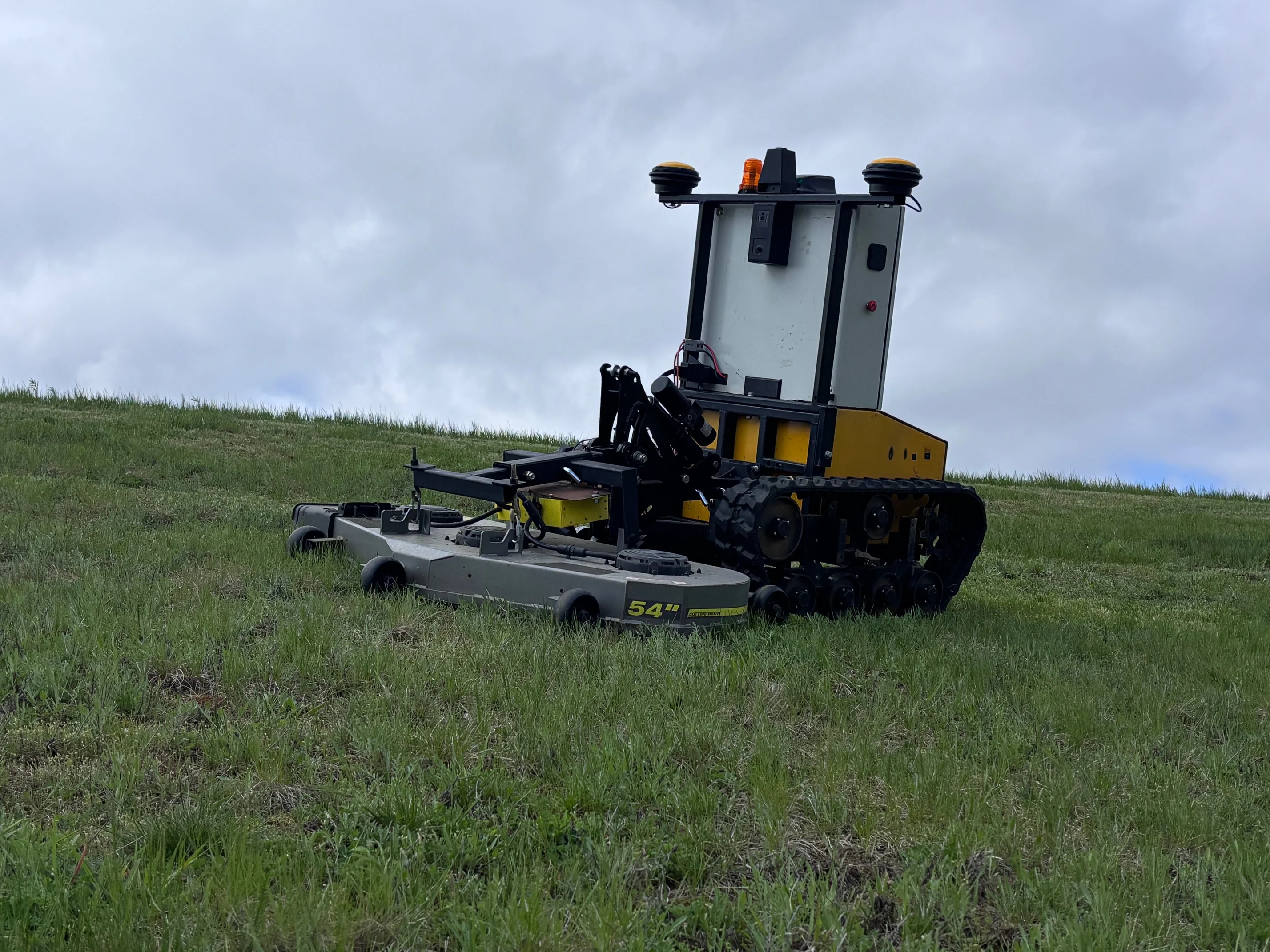 Snowbotix autonomous robot mowing a grassy slope at ACM